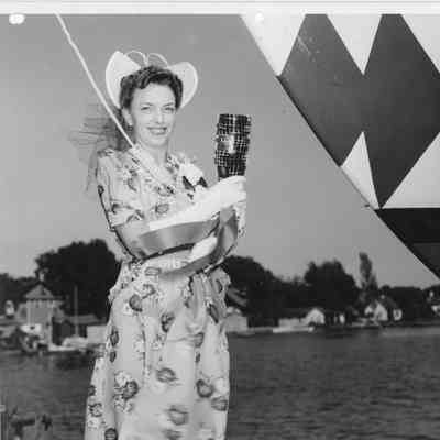 Woman holding christening bottle next to P-570 at Peterson Boat Works June 17, 1944