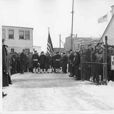 Portion of band and crowd by gate for ship launching