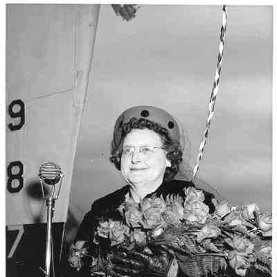PC-822 ship sponsor holding roses in front of vessel