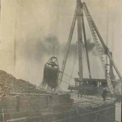 Workers using crane with bucket