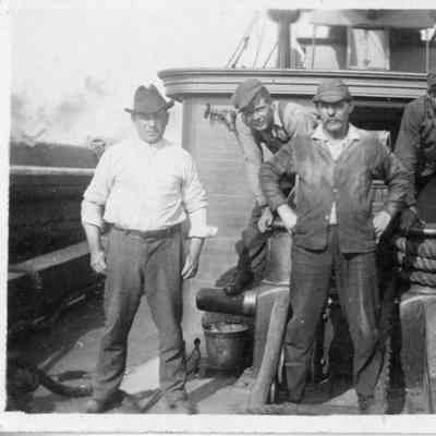 Five men standing on deck of vessel