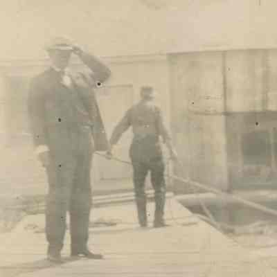 Two workers behind well dressed man