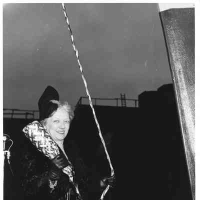 Mrs. Edward Frick holding bottle of champagne