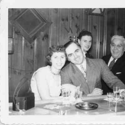 Four people at bar during naval office party