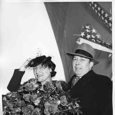 Mrs. W. H. Gallieane holding roses alongside man in a hat