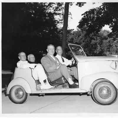 Four unidentified men in light colored sports car