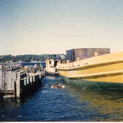 Green and yellow boat dragging boats