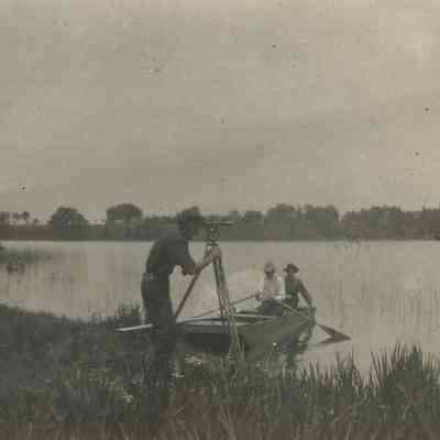 Surveyor using transit along shoreline