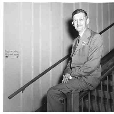 Wolcott E Spofford sitting on banister near shipyard
