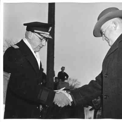 Rear Admiral William C. Watts shaking hands with L.D. Smith