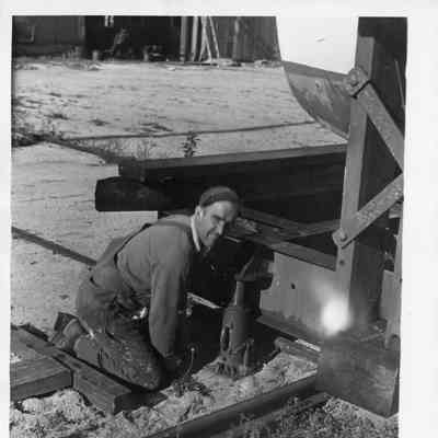 Employee B. Drexler at work kneeling on ground at Peterson Builders 1947