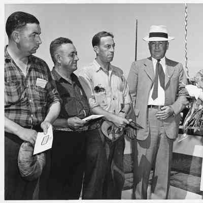 Leathem D. Smith, three men, and PC-1173 ship sponsor next to vessel