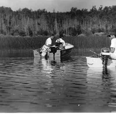 Two groups of people fishing on motor boats