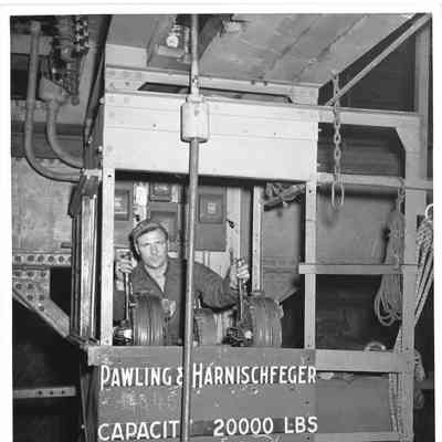 Man behind controls of machine with "Pawling & Harnischfeger Capacity 20000 lbs" on front