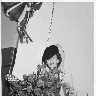 Mrs. Gus Johnson holding roses at christening of PF-64 USS Knoxville