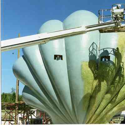 Large shell on ground with crane with two workers 1989