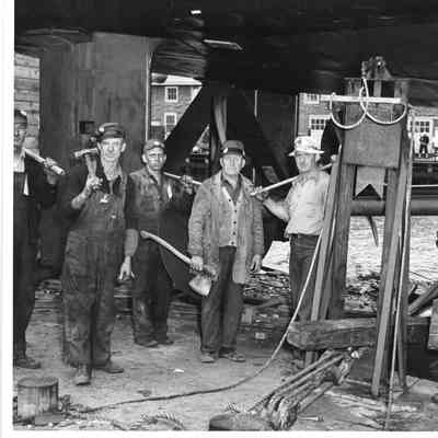 John Klaus and group of workers at shipyard with guards in background