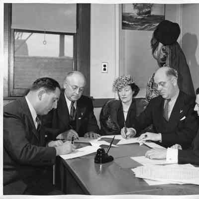 Captain Polking Horne, L.D. Smith, Mrs. Gallieane, Rob Carruthers signing documentation