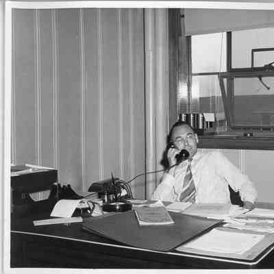 Frank Blinks Behringer at desk with phone