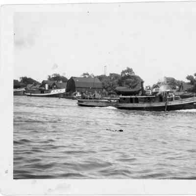 Tugboat underway next to docked vessels