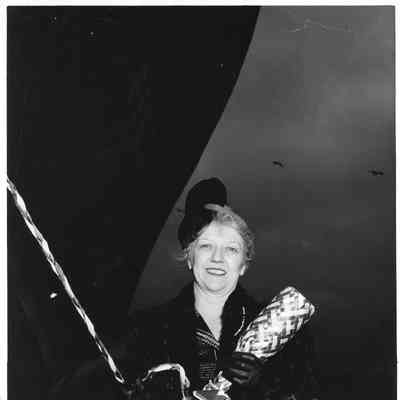 Mrs. Edward Frick holding bottle of champagne