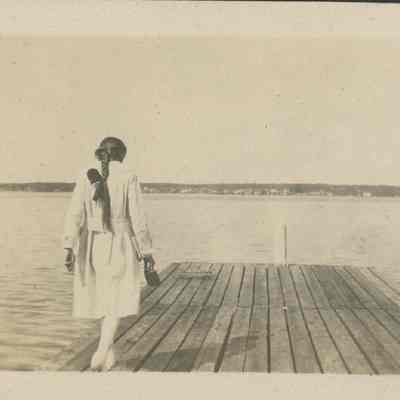Woman walking on pier in Baileys Harbor 1919