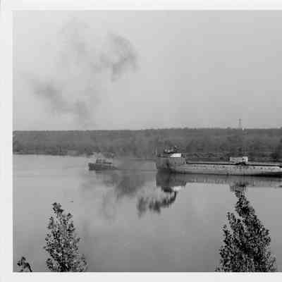 Roen tugboat towing freighter with crane