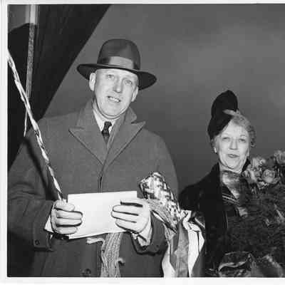 Mr. and Mrs. Edward Frick holding Champagne bottle and roses