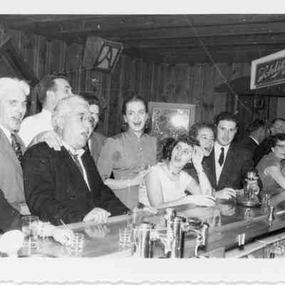 Leo La Mere and group at bar during naval office party