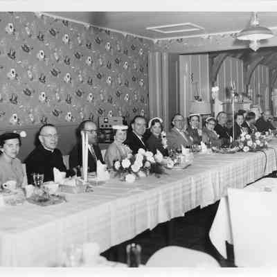 People sitting at table during launch party of LST-1170, May 22, 1954
