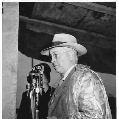 Leathem D. Smith wearing raincoat at WHBL microphone