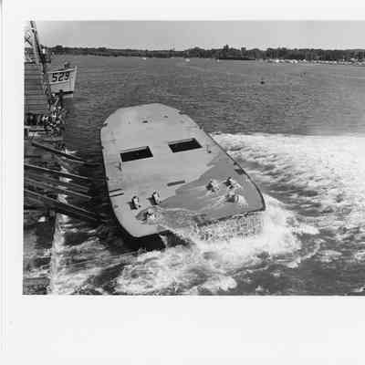 95' tug hull in the water, water running off deck
