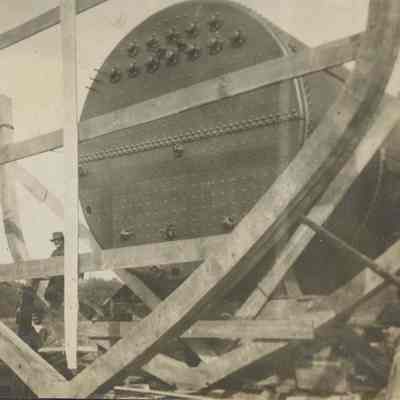 Men next to ship's boiler in frame