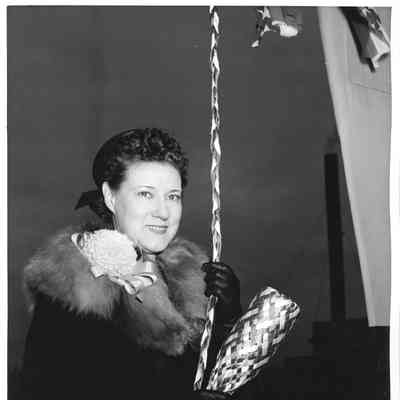 Mrs. E. A. Washburn holding bottle of Champagne