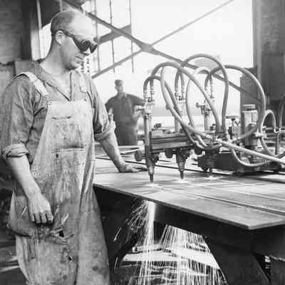 Man in welding goggles butting metal with a machine