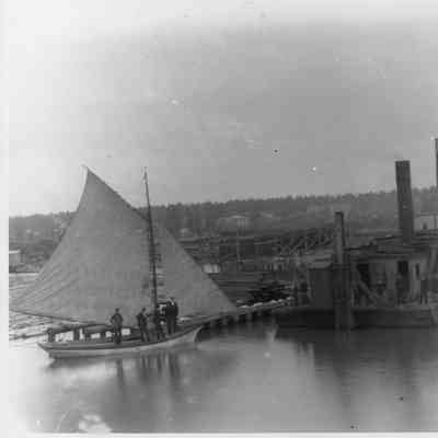 Sailing vessel at left with five men standing on deck
