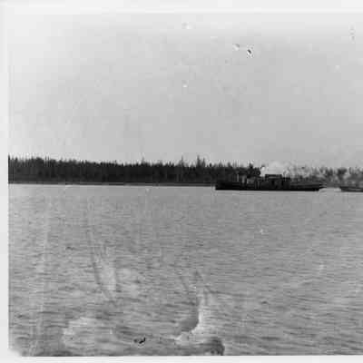 Unidentified vessel towing boarge with lumber