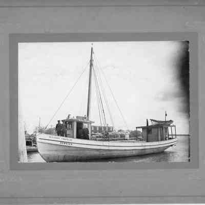 Vessel Service dockside with four men standing on deck