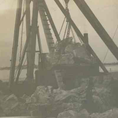 large quarry rock being loaded onto a crane