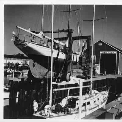 Travelift holding sailboat at dock