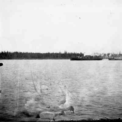 Tugboat towing barge loaded with lumber in Bay of Sturgeon Bay April, 1961