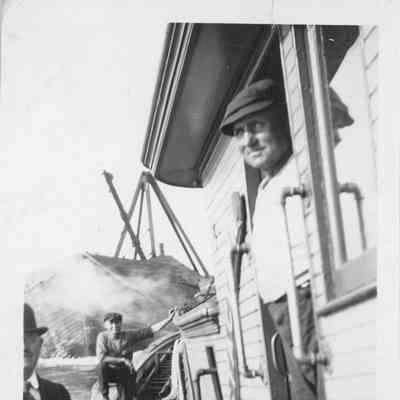 Three men on deck of vessel towing vessel