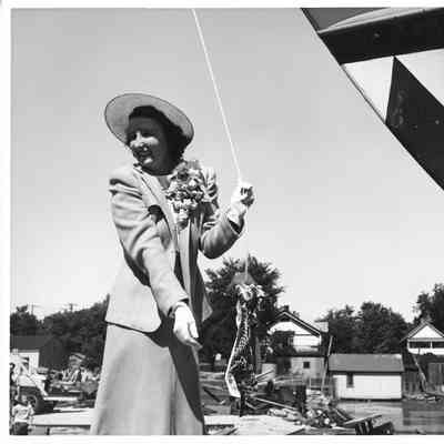 P-571 ship sponsor holding christening bottle post-christening at Peterson Boat Works July 15, 1944