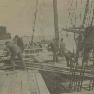 Workers loading or unloading lumber