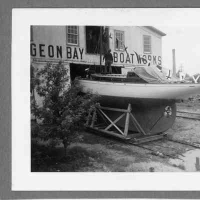 Sailboat in cradle in front of Sturgeon Bay Boat Works