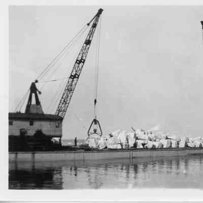 Pile of limestone on barge Transport with two cranes