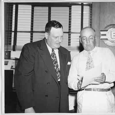 Unidentified man, L.D. Smith talking in office