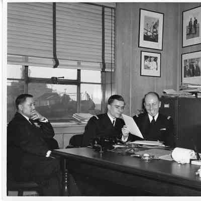 L.D Smith with group and USS Evansville visible in background