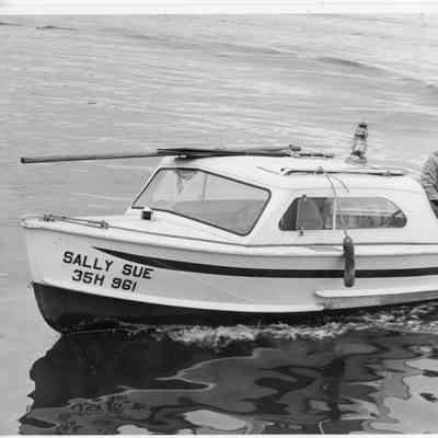 Man next to outboard motor on vessel Sally Sue