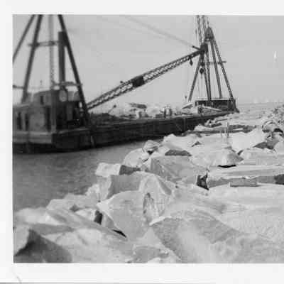Crane barge next to breakwater